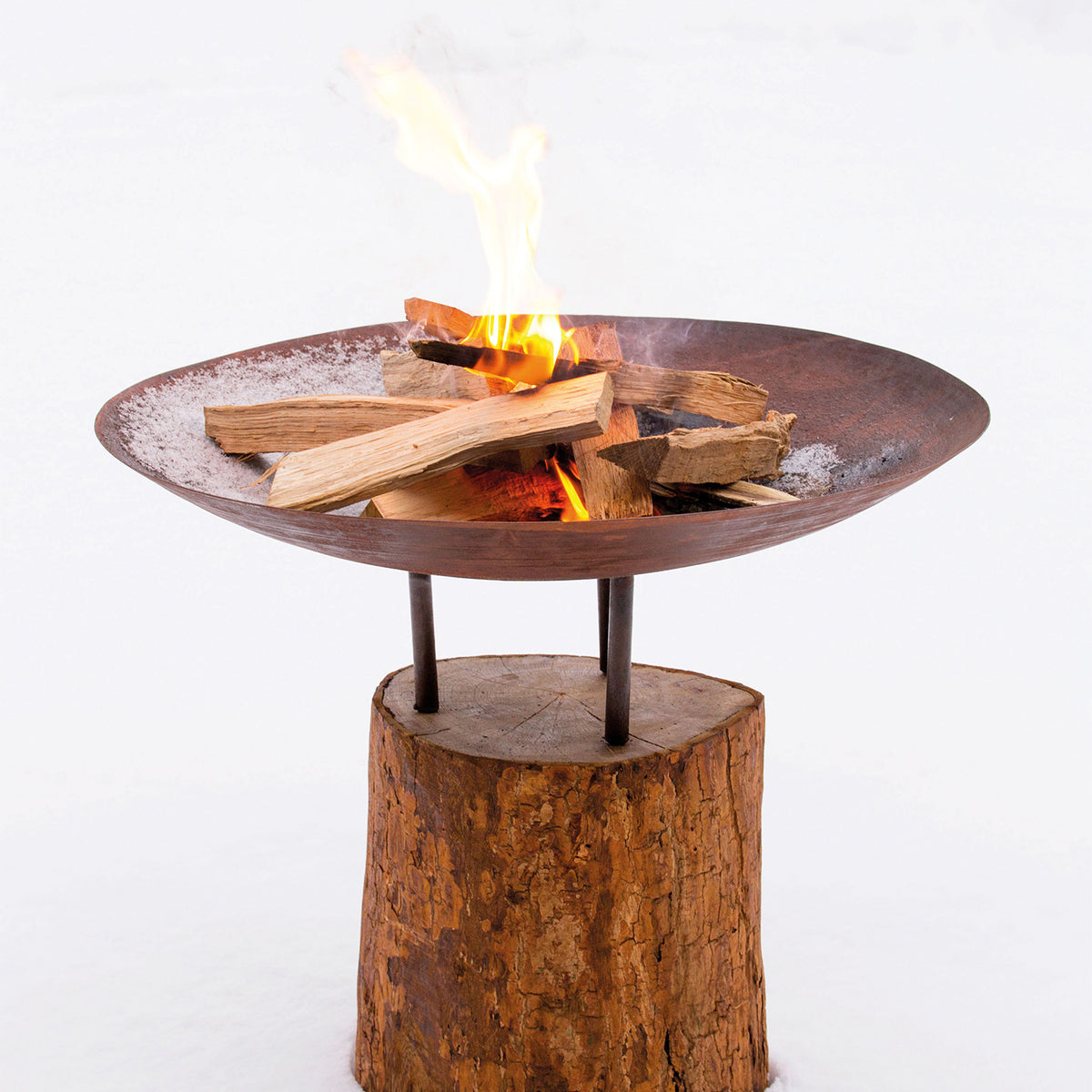Corten-tulisija puunkannolla